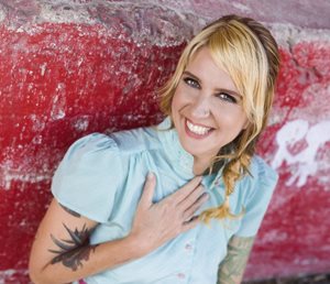 Christi Baker against a bright red background.