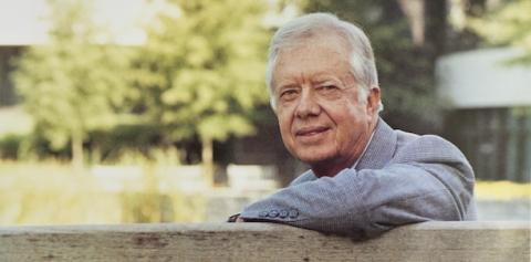 President Jimmy Carter, leaning over the back of a bench.