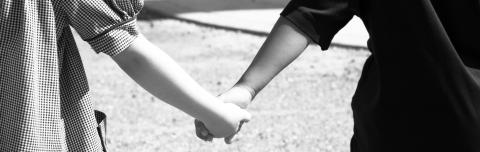 Two people holding hands in New Orleans, this image recognizes strength and resiliency.