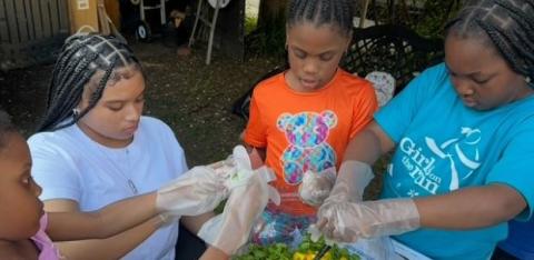Girls work together to make salad.