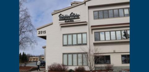 NeighborWorks Alaska, a tannish building with lots of windows against a blue sky.