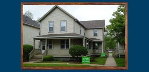 A house with a green open house sign in fron tof it.